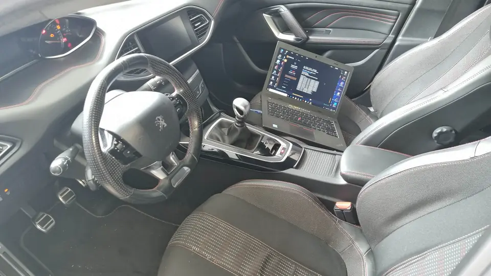 Ordinateur portable de diagnostic posé sur le siège d’une Peugeot 308 GTi