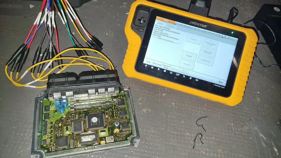 Calculateur Volkswagen Bosch EDC15P+ relié à un faisceau de banc, à côté d’une tablette OBDSTAR